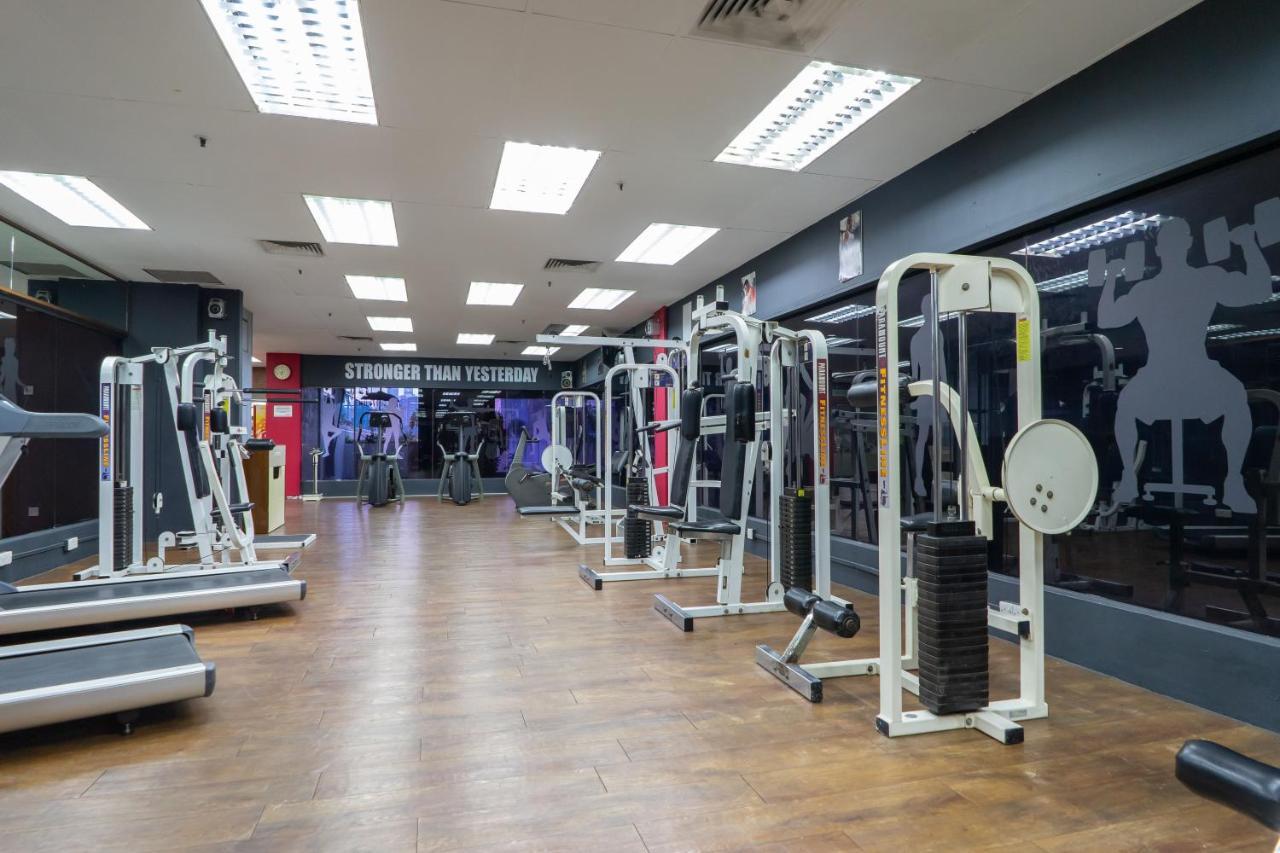 吉隆坡斯里太平洋酒店 外观 照片 The photo shows an empty gym interior equipped with various exercise machines. The floor is made of wood, and the lighting is bright, coming from ceiling fixtures. On one wall, there is a motivational message that reads "Stronger Than Yesterday." The